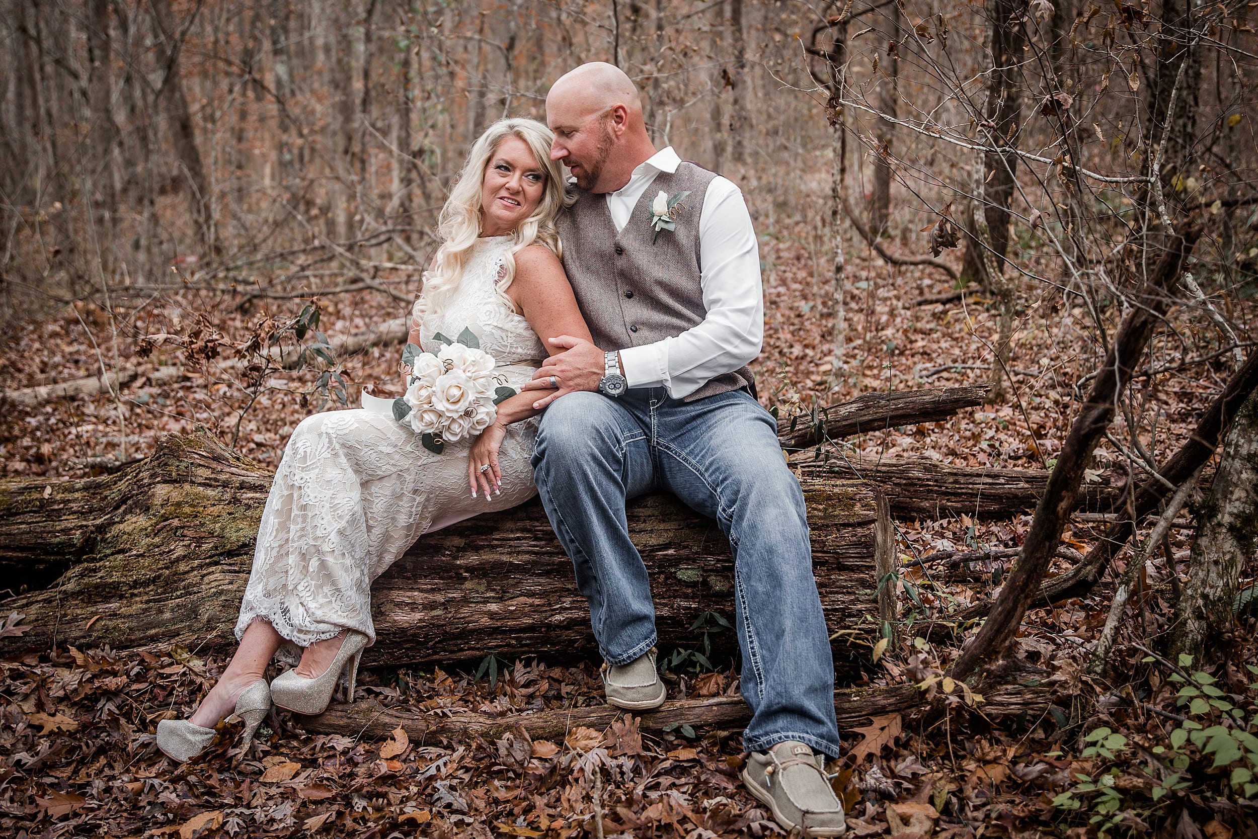 Bride and groom on log at outdoor micro wedding in the smokey mountains