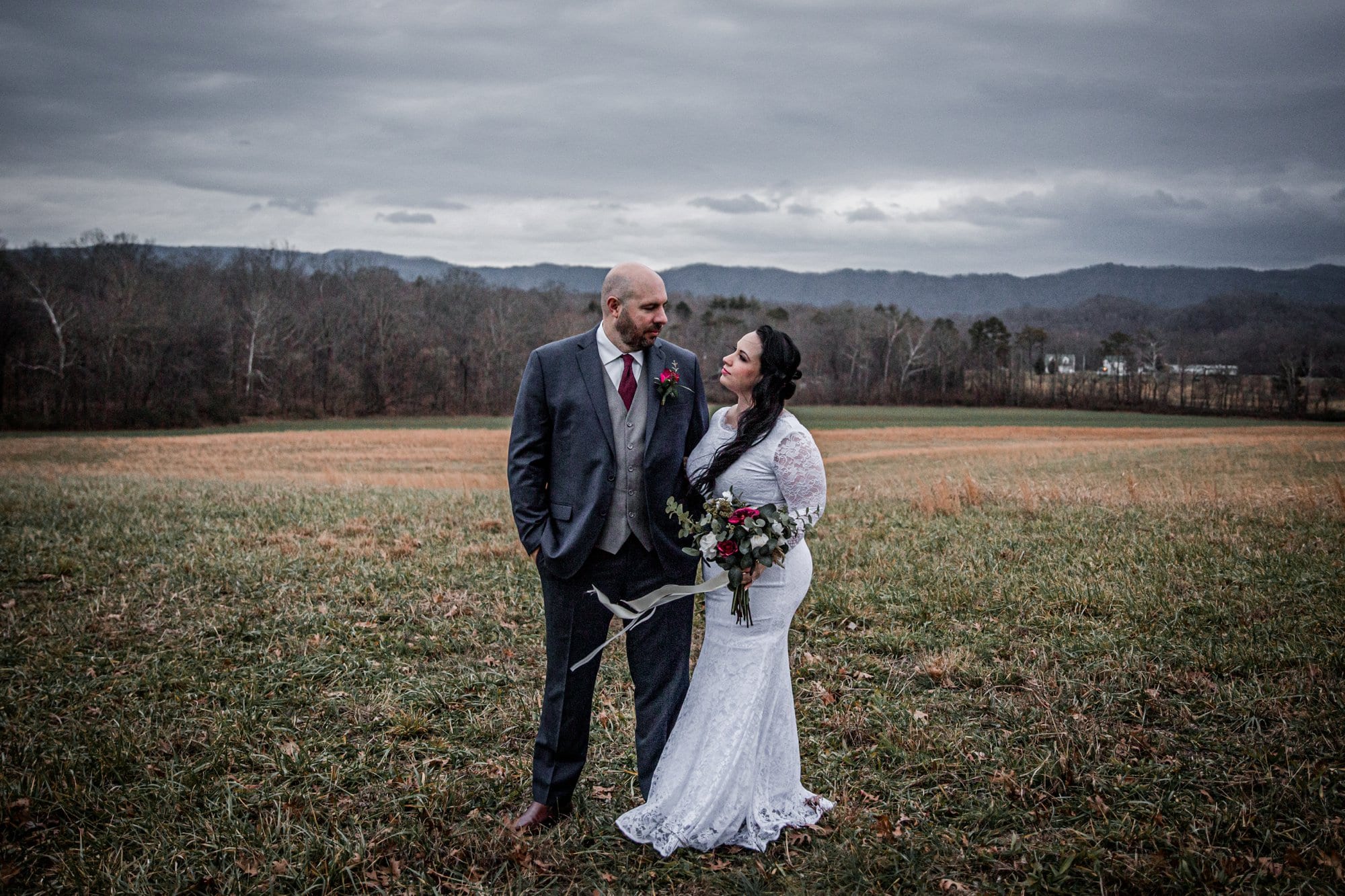 Bride and groom outdoors in front of mountains after ceremony at Chapel in the Hollow during a Gatlinburg elopement. 