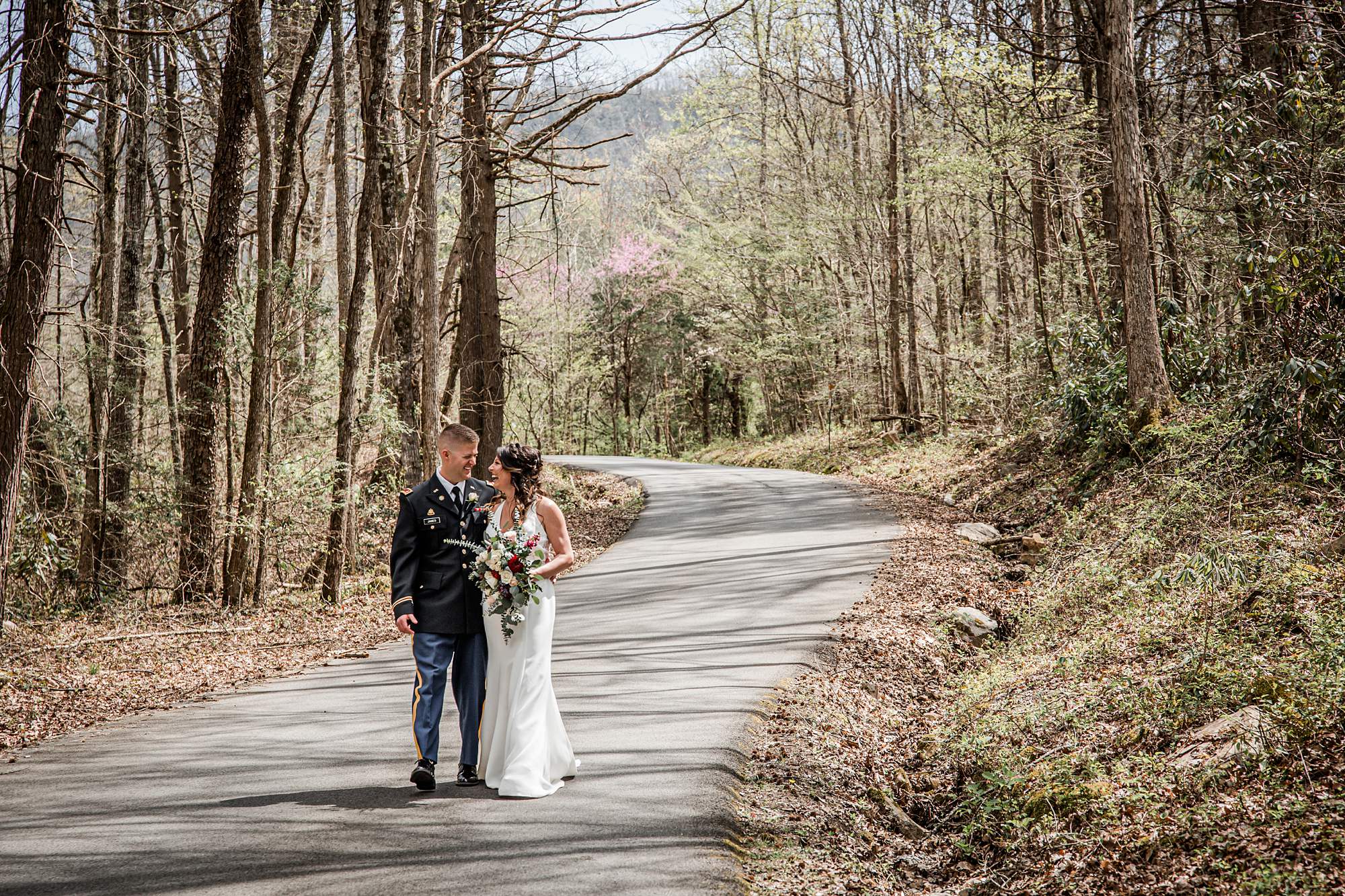 Bride and Groom walking along wooded road 