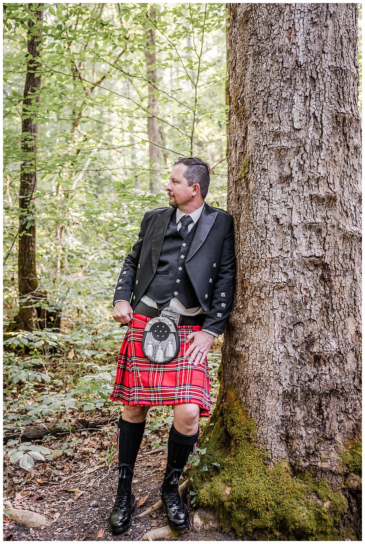 groom in a kilt outside in forest